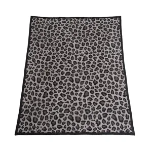 Dettaglio coperta in maglia con stampa leopardata, morbido plaid con bordo nero.