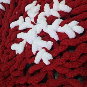 Détail de la couverture flocon de neige en tricot épais rouge et blanc, douce chenille