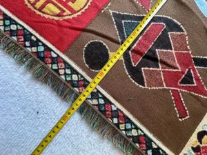 Detailansicht der gewebten Jacquard-Decke mit einzigartigen geometrischen Mustern und Fransen.