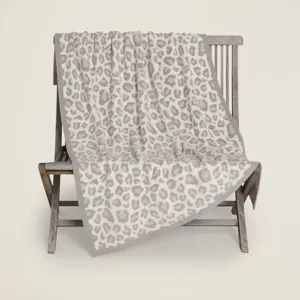 Dettaglio coperta leopardata in maglia con consistenza morbida e decorazione calda.