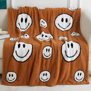 Brown fluffy knit throw blanket with trendy white wavy smiley face pattern, soft couch blanket.