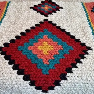 Chunky knit blanket with bohemian diamond geometric pattern, cozy woven throw for home decor.