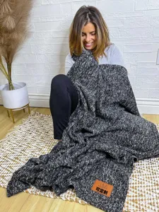 Cozy autumn and winter knitted blanket with black and white pattern, soft and warm cover.