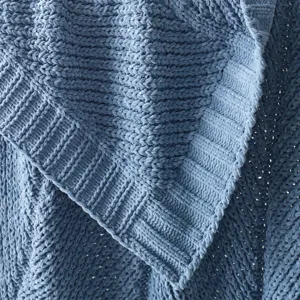 Close-up macro detail of soft blue knit blanket showing cozy ribbed edge fabric texture.