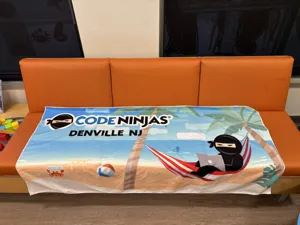 Vista di dettaglio del telo mare in microfibra stampato con grafica a tema spiaggia e ninja.
