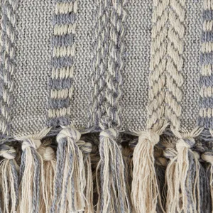 Vue détaillée d'un plaid en jacquard tissé avec des franges élégantes pour la décoration.