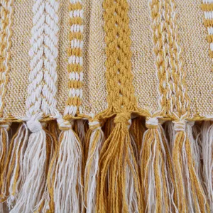 Gros plan détaillé de la couverture à franges jacquard tissée, texture douce et rayures jaunes.