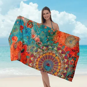 Vista dettagliata di un telo mare con stampa mandala colorata tenuto da una modella al mare.