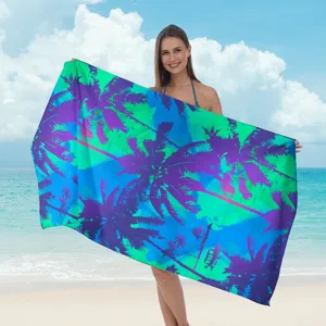 Vista dettagliata del telo mare in microfibra con stampa di palme tropicali vivaci.