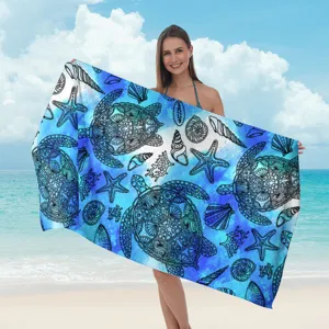 Telo mare in microfibra blu con eleganti stampe dettagliate di tartarughe e conchiglie marine.