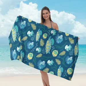 Vista dettagliata del telo mare in microfibra con stampa oceanica di tartarughe e coralli.
