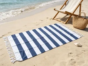 Telo mare a righe blu e bianche con nappe, ideale per vacanze estive al mare e relax in spiaggia.