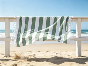 Telo mare turco a righe verdi e bianche appeso alla staccionata al sole in dettaglio.