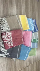 Colorful Turkish beach towel with fringe and striped design, perfect for outdoor travel.