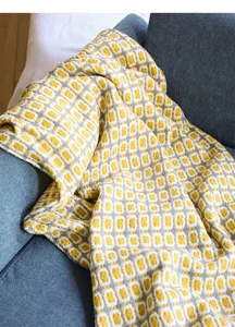 Nahaufnahme Detail der gelben und grauen geometrischen Muster Decke auf dem Sofa.