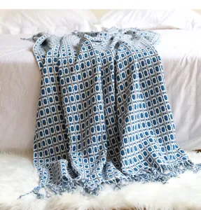 Gewebte Wohndecke mit blau-weissem Muster und Fransen fuer die Schlafzimmerdekoration.