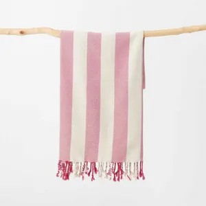 Telo mare in cotone a righe verticali rosa e bianche con frange dettagliate appeso.