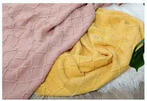 Kuschelige Strickdecke mit Fransen für gemütliche Stunden auf dem Sofa im Wohnzimmer.