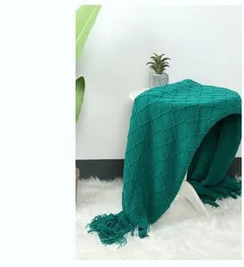 Gemütliche grüne Stricktagesdecke mit Fransen, perfekte Textur für Sofa und Schlafzimmer.