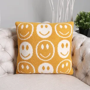 Yellow knitted throw pillow cover featuring white smiley faces, cozy soft sofa cushion.