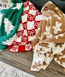 Detailed view of cozy Christmas sherpa fleece blankets featuring cute gingerbread man and tree designs.