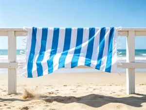 Telo mare a righe blu e bianche con frange, ideale per le vacanze estive e i viaggi all'aperto.