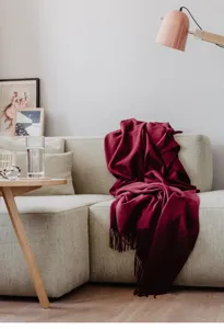 Cosy merino wool throw blanket in rich burgundy for living room sofa and bedroom decor detail
