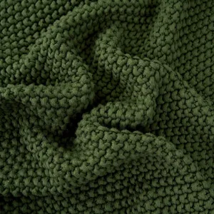 Gezellige donkergroene gebreide deken plaid voor bank en bed, zachte acryl textuur thuis.