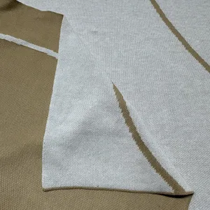 Knitted jacquard blanket fabric detail showing soft texture and geometric pattern design.