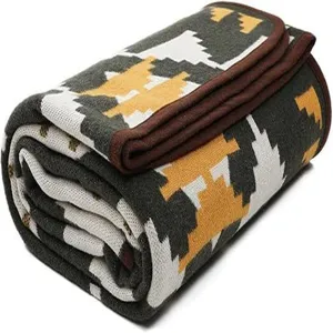 Close-up of a cozy geometric woven jacquard blanket with stylish brown border trim.