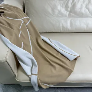 Close-up detail view of the soft knitted jacquard blanket featuring geometric lines.