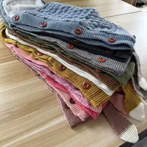 Multifunctional knitted baby sleeping bag with plush lining and wooden buttons, multi-color.