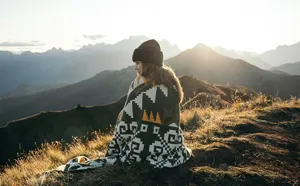 Cozy woven jacquard wool blanket with ethnic geometric pattern, warm winter throw for outdoor use.