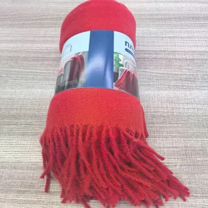 Vista dettagliata della coperta con frange rossa arrotolata ordinatamente con etichetta.