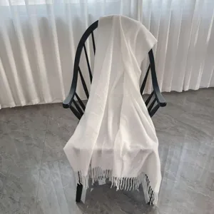 Coperta da lancio in poliestere tinta unita con frange drappeggiata su sedia per la casa.