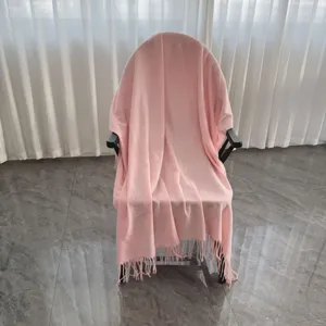Coperta rosa unita con frange, dettaglio elegante di coperta decorativa per un ambiente accogliente.