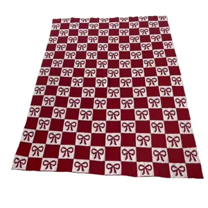 Cozy red and white checkerboard knit blanket featuring cute bow patterns for home decor.