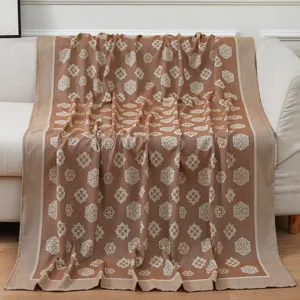 Detailed view of the brown woven blanket featuring a classic floral medallion pattern.