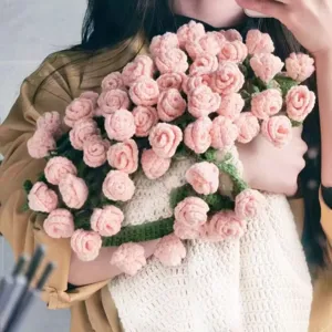 Detailed view of handmade crochet rose blanket, soft pink floral design for cozy home decor.