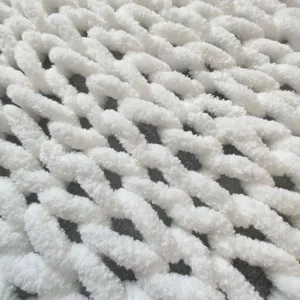 White chunky chenille yarn knit blanket texture detail close up soft cozy couch throw rug.