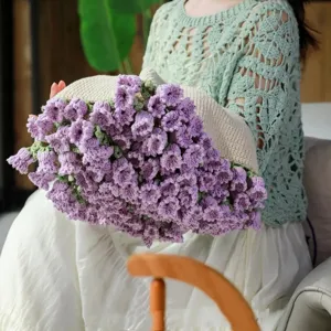 Close-up detail of handcrafted crochet purple flower bouquet blanket, soft texture handmade gift.