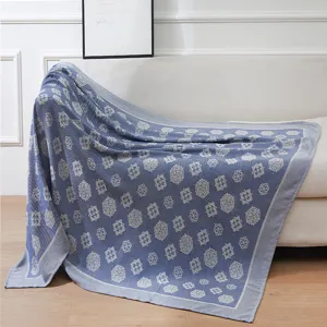 Blue woven throw blanket with traditional floral pattern for sofa and air conditioned room use.