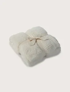 Cozy folded plush throw blanket detail view, soft fleece texture, elegant ribbon tie, warm decor.