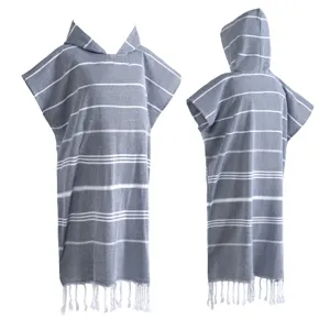 Detail van de griekse Turkse strandhanddoek poncho met capuchon, witte strepen en franje zoom.