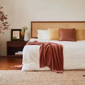 Cozy knitted throw blanket in terracotta color, perfect for living room sofa or bedroom bed.