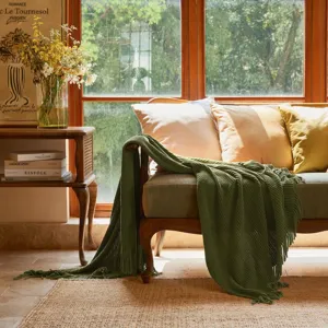 Green knitted throw blanket for couch sofa, soft textured blanket with fringe detail for living room.