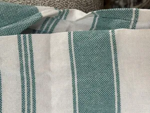 Detail shot of green and white striped woven cotton towel fabric texture close up