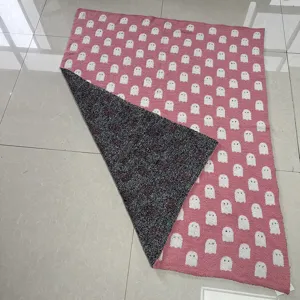 Pink knitted jacquard blanket featuring cute white ghost pattern, cozy soft throw rug.