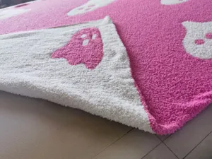 Close up view of the cute ghost pattern fleece blanket detail, showing soft knitted texture.