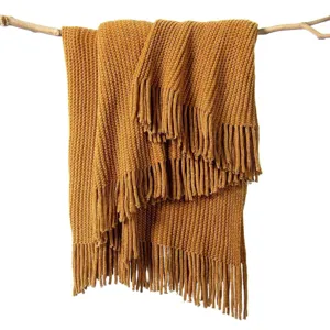 Amber yellow ribbed knit throw blanket detail showing soft textured fabric and fringe.